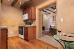 Fully equipped kitchen with warm wood finish and viga ceilings
